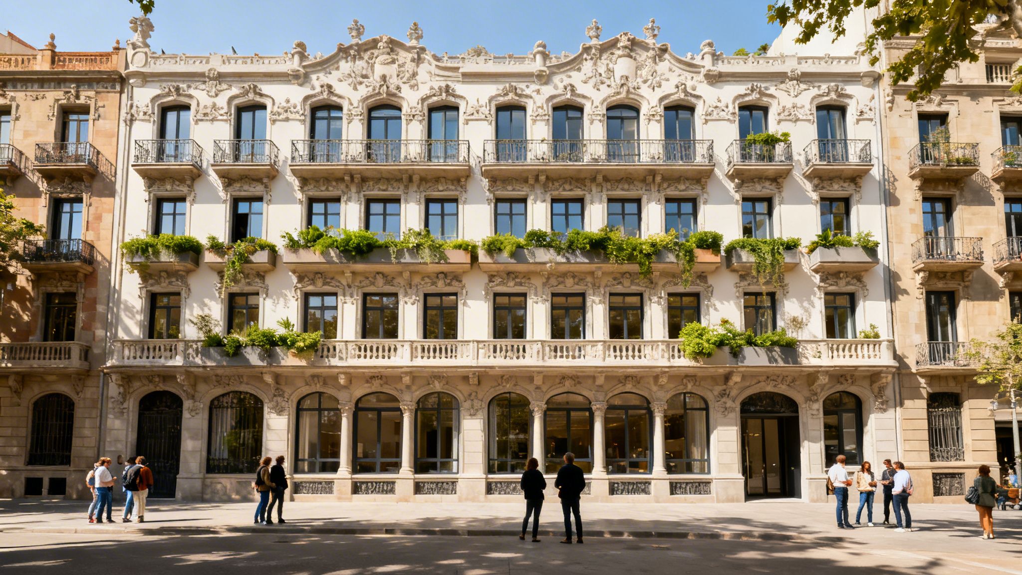 Majestuoso edificio blanco ornamentado con balcones y plantas verdes en Barcelona, con gente en la calle.